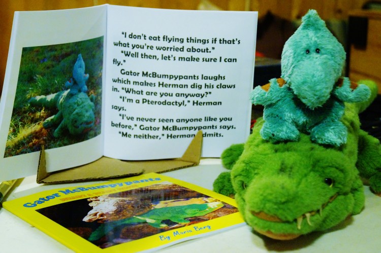 Herman rides on Gator McBumpypants' head next to their book.