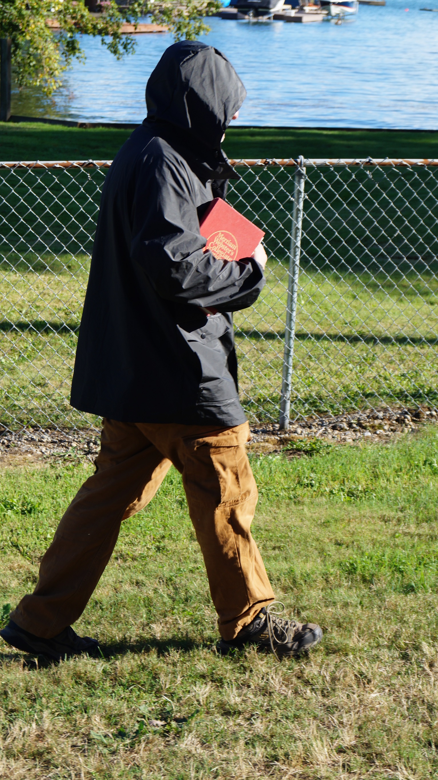Man carrying dictionary by a lake