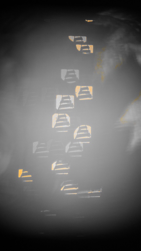 Yellow background bokeh train tracks and a few leaves in a an oblong globe of grey.