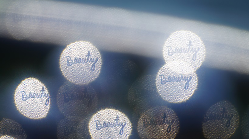 Five textured light circles with the word Beauty written in cursive in their centers.