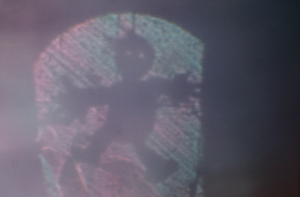 A layered image displaying a shadow of a marionette with a textured background, symbolizing inanimate objects coming to life.