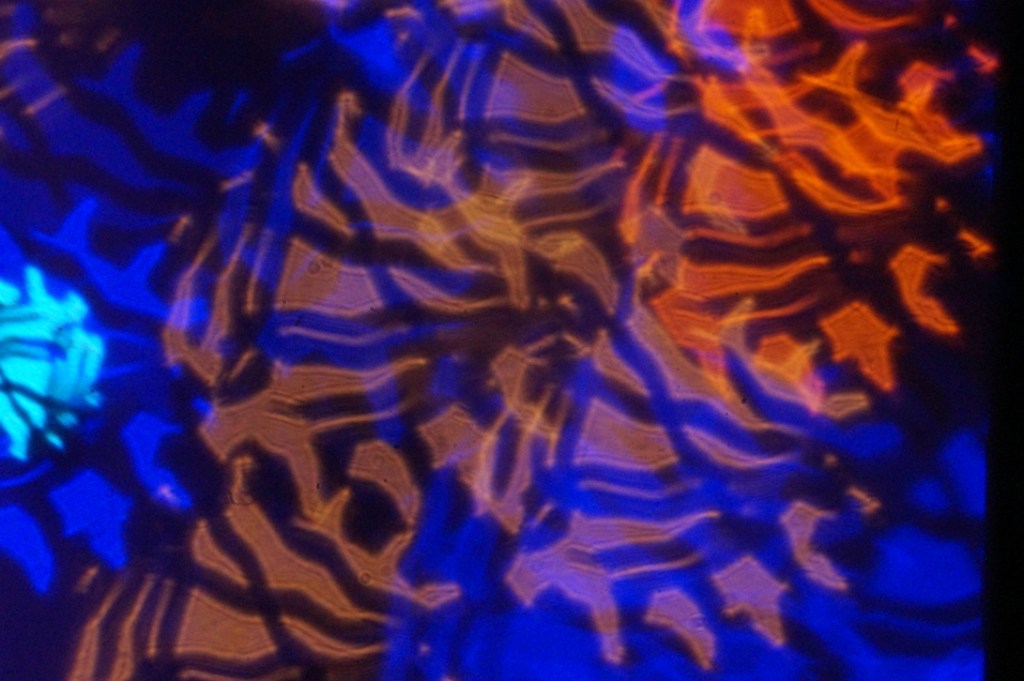 Abstract image featuring vibrant blue and orange patterns resembling flowing water or light reflections.