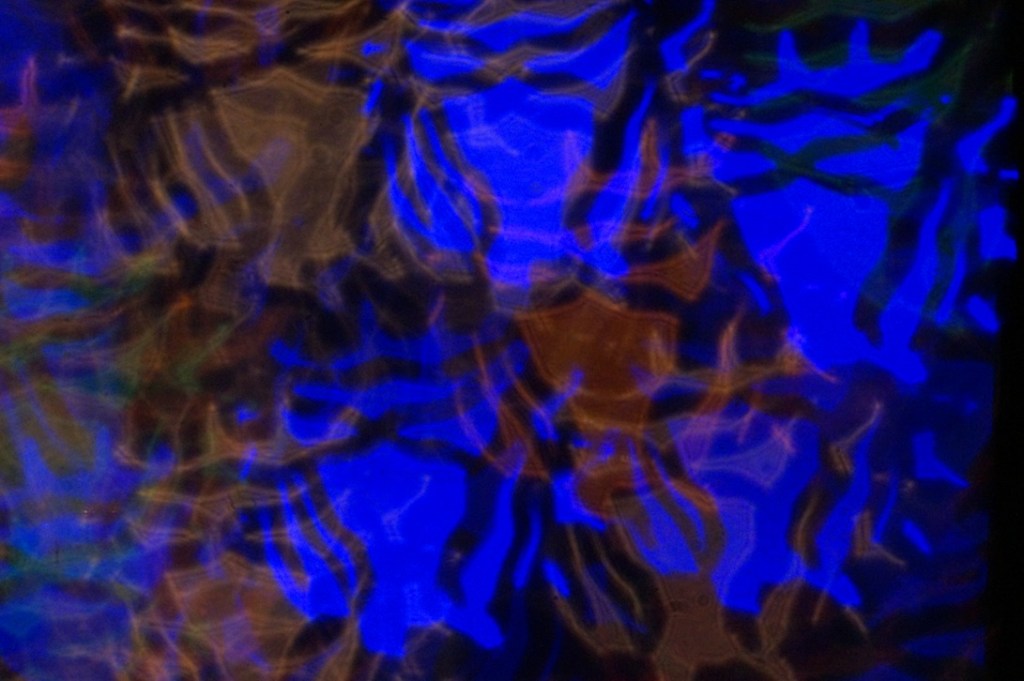 An abstract image featuring vibrant blue and brown ripples, creating a wavy, textured surface that evokes a sense of fluidity and movement.